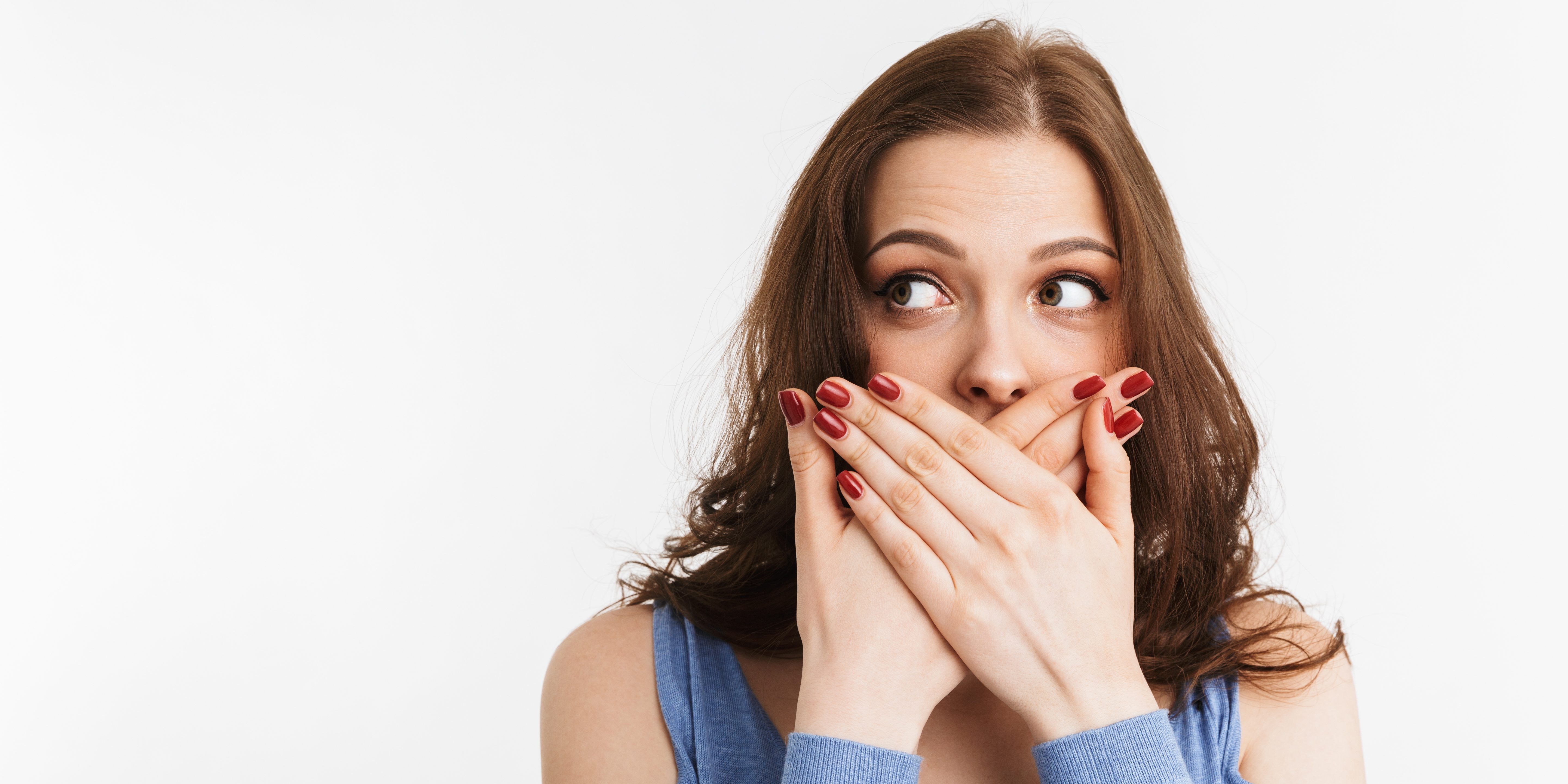 Portrait of a surprised young woman covering mouth